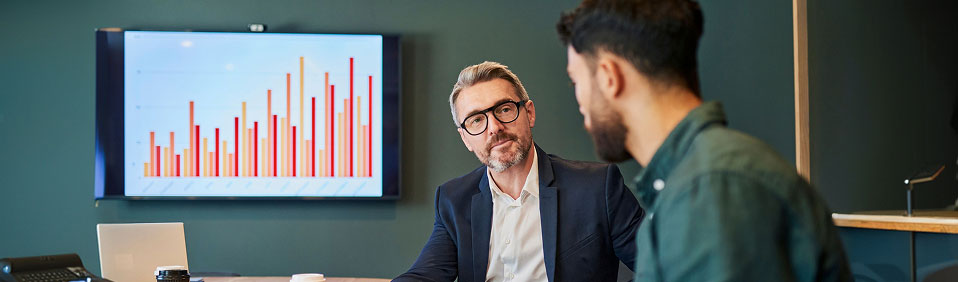 Two people talking in a conference room
