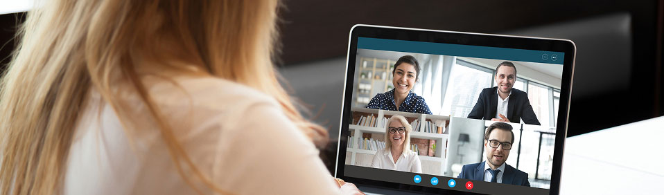 A woman sitting at a laptop computer attending a virtual conference call.